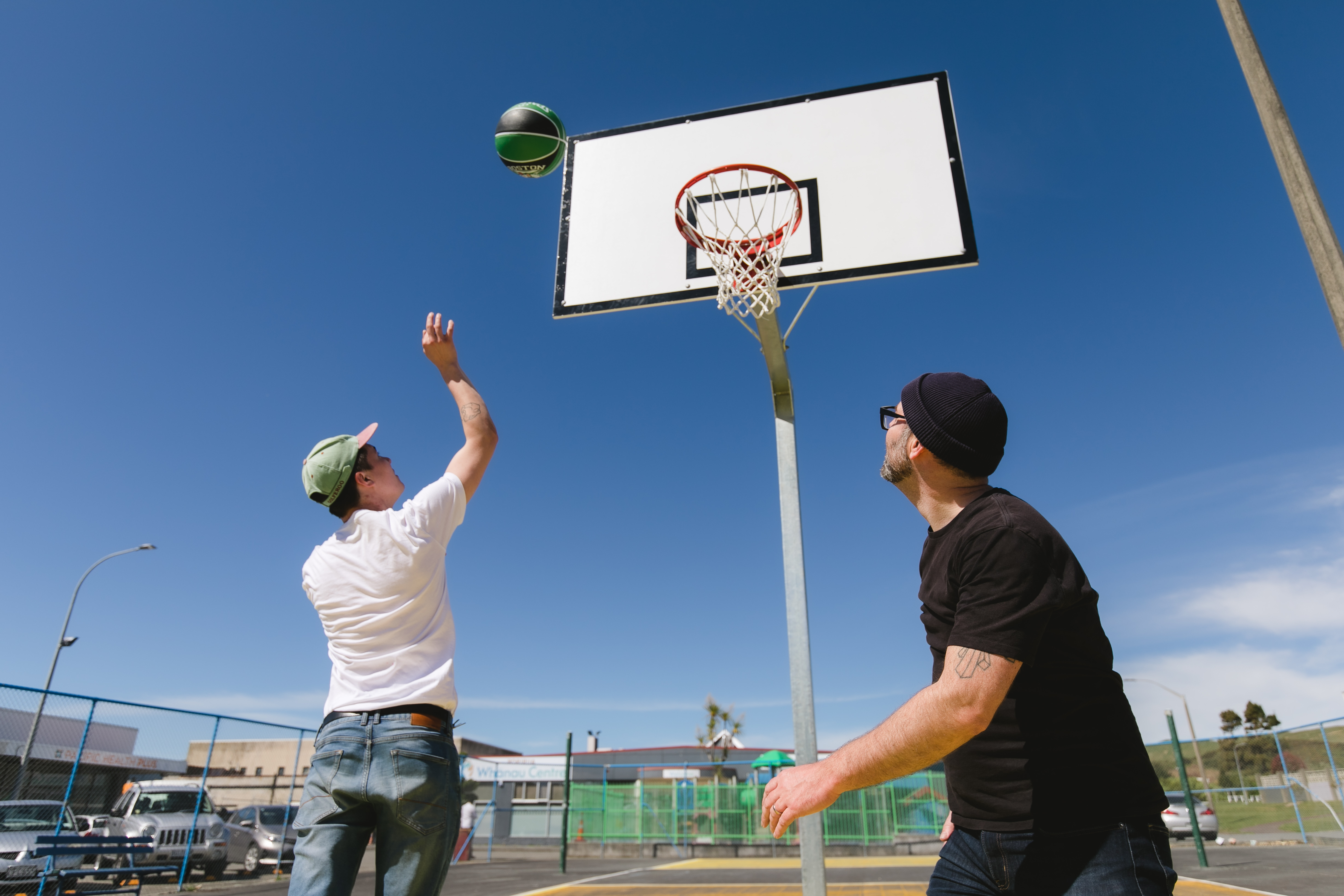 Teen ang youth worker playing basketball